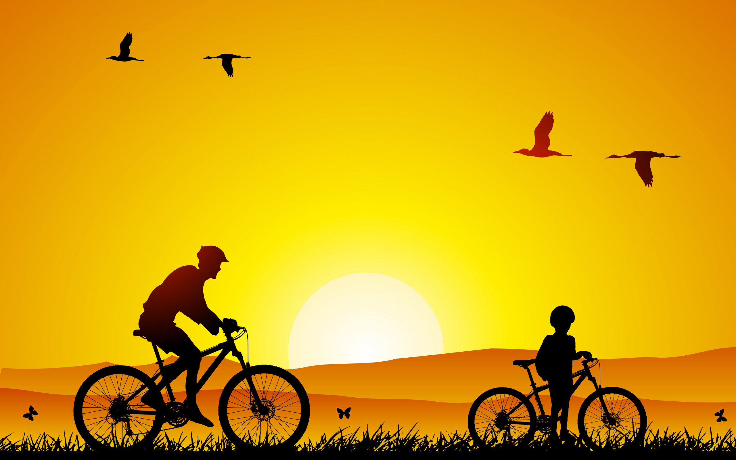 papà e bambino in bici al tramonto